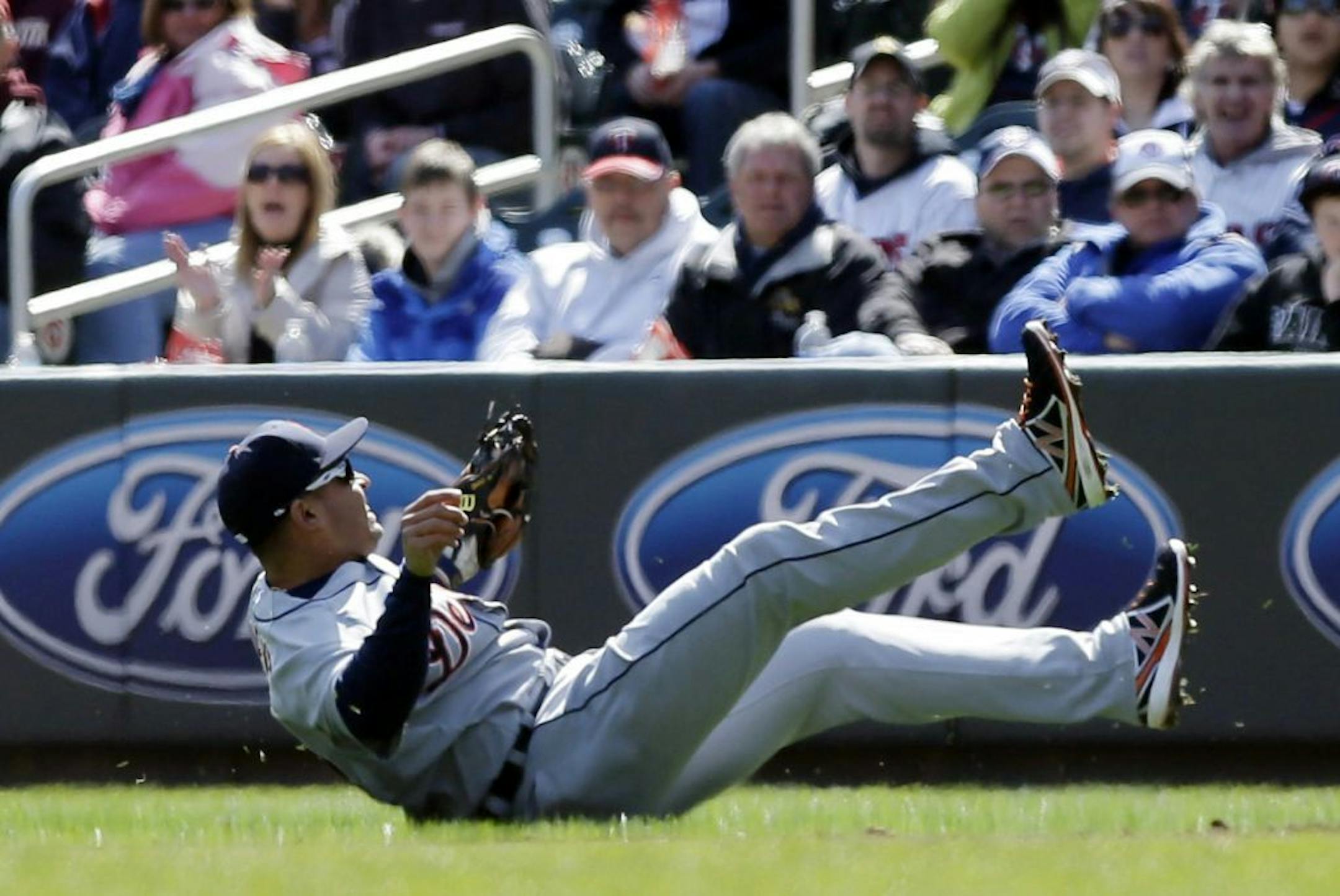 Detroit Tigers' Omar Infante tumbles after falling to field a single hit by Minnesota Twins' Justin Morneau during the first inning of a baseball game, Thursday, April 4, 2013, in Minneapolis.