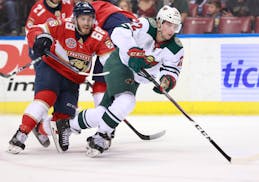Florida Panthers left wing Mike Hoffman (68) and Minnesota Wild left wing Kevin Fiala (22) battle for the puck during the first period of an NHL hocke