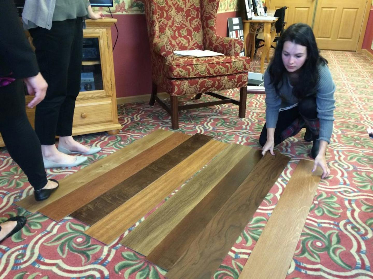 Hayley Hill, an interior design student at Century College, lays out flooring samples for approval. Hill and other students are redesigning a suite at the Pines, a senior living facility in Richfield.