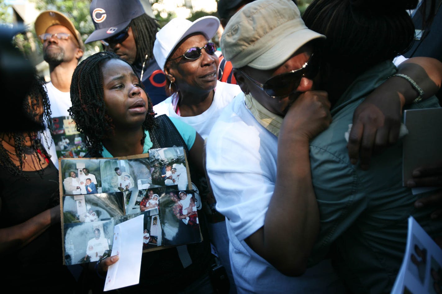 Relatives of Katricia Daniels and Robert Shepard mourned them in front of the house during a vigil Monday night. About 200 people — family members, friends and neighbors — marched from the home to Dr. Martin Luther King Jr. Park in Minneapolis. In front, from left, are Daniels' daughter Brandy Daniels (holding the pictures) aunt Lorean Daniels, mother Shirley Daniels and sister Shatara Daniels. In the background, looking up, is Daniels' boyfriend, Joe Williams.