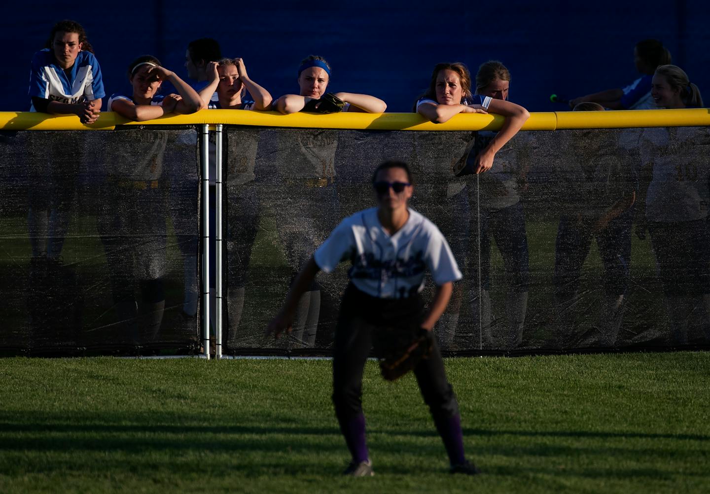 Esko players watched a game from the outfield fence as they waited for their game to start last June 6 at the girls' softball state tournament in North Mankato. ] CARLOS GONZALEZ • cgonzalez@startribune.com – North Mankato, MN – June 6, 2019, Caswell Park, High School / Prep state softball semifinals,