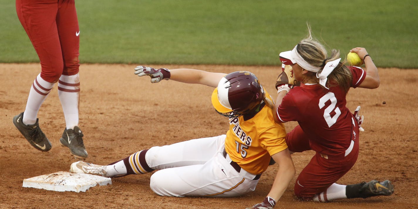 Alabama second baseman Demi Turner tumbles over Minnesota baserunner Erika Rozell after tagging her out during Alabama's 1-0 win over Minnesota in the NCAA Tuscaloosa Regional championship game Sunday, May 20, 2017 in Rhoads Stadium in Tuscaloosa, Ala. (Gary Cosby Jr./The Tuscaloosa News via AP)