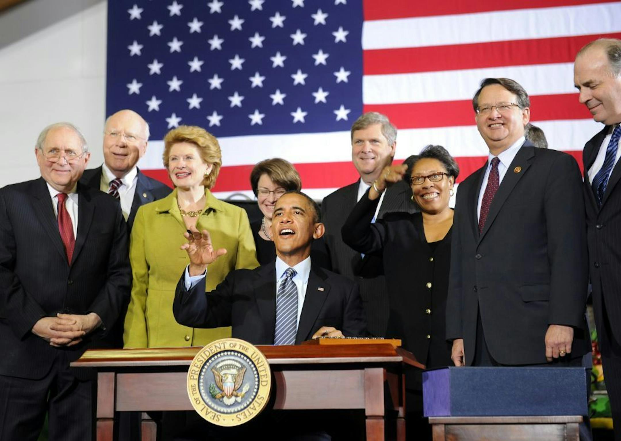 President Barack Obama, center, joined by politicians including, from left, Sen. Carl Levin, D-Mich., D-Mich., Sen. Patrick Leahy, D-Vt., and Senate Agriculture Committee Chair Sen. Debbie Stabenow, D-Mich., as he gets ready to sign the farm bill, Friday, Feb. 7, 2014, at Michigan State University in East Lansing, Mich.