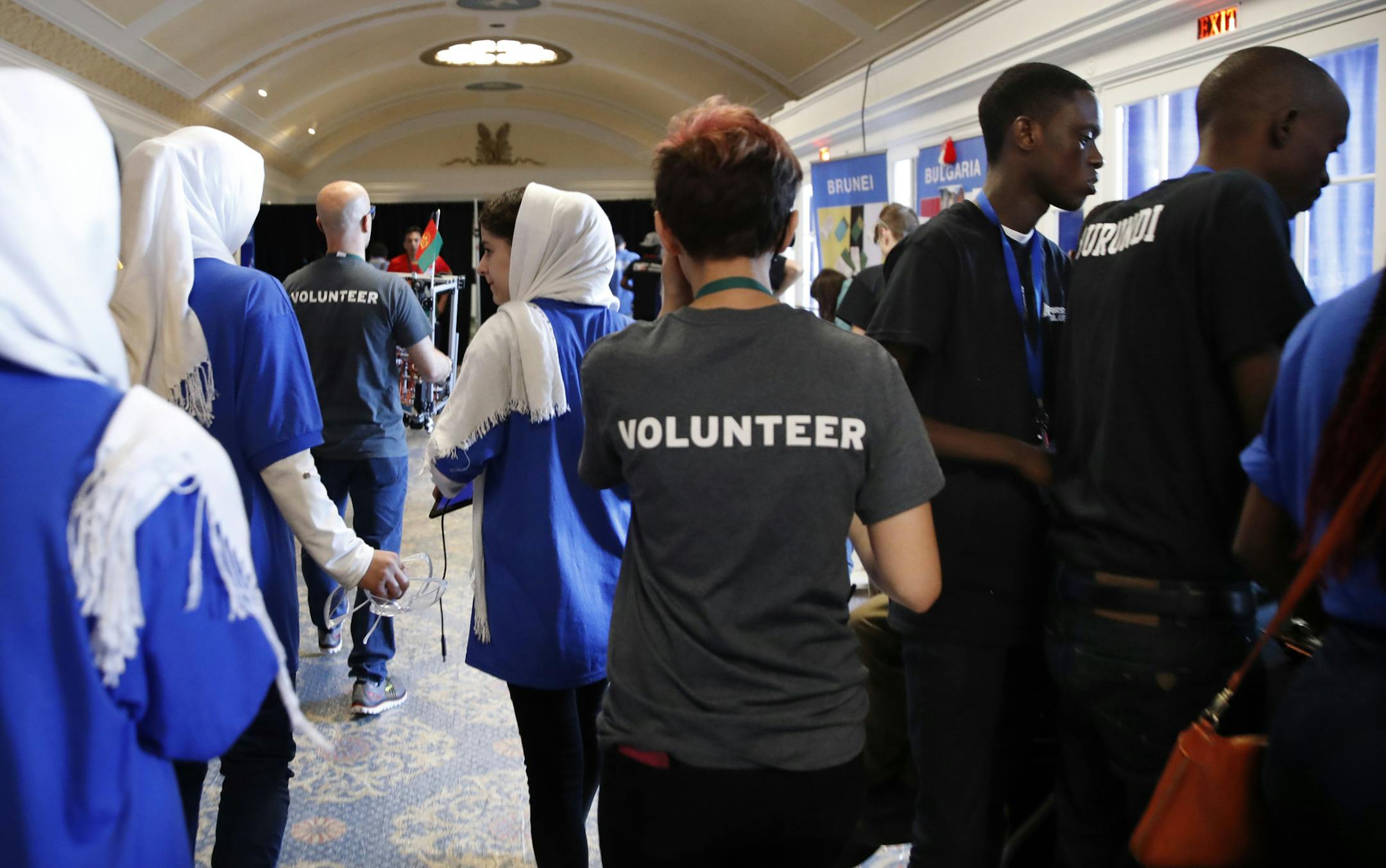 In this July 17, 2017, photo, the Afghanistan team, left, walks past two of the team members from Burundi, at right in black shirts, during the FIRST Global Robotics Challenge in Washington. Police tweeted missing person fliers Wednesday asking for help finding the teens, who had last been seen at the FIRST Global Challenge around the time of Tuesday's final matches. The missing team members include two 17-year-old girls and four males ranging in age from 16 to 18. (AP Photo/Jacquelyn Martin)