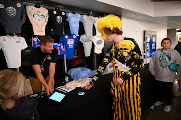 Does this come in a size GOAT? Iowa fan Parker Spindler of Becker, Minn., buys a shirt at a Target Center stand Thursday, the day before star player C