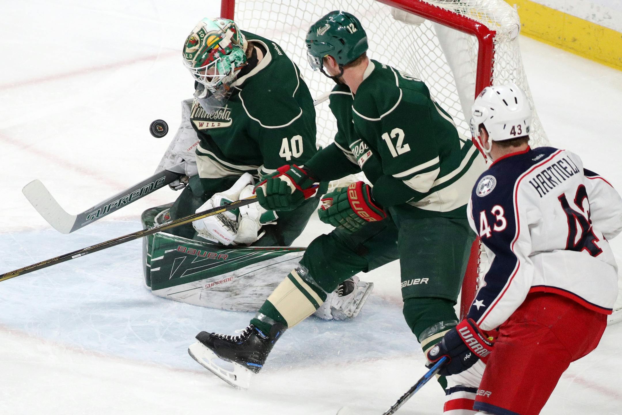 Minnesota Wild goaltender Devan Dubnyk (40) stops a shot from Columbus Blue Jackets left wing Scott Hartnell (43) as Minnesota Wild center Eric Staal (12) tries to defend during the first period.