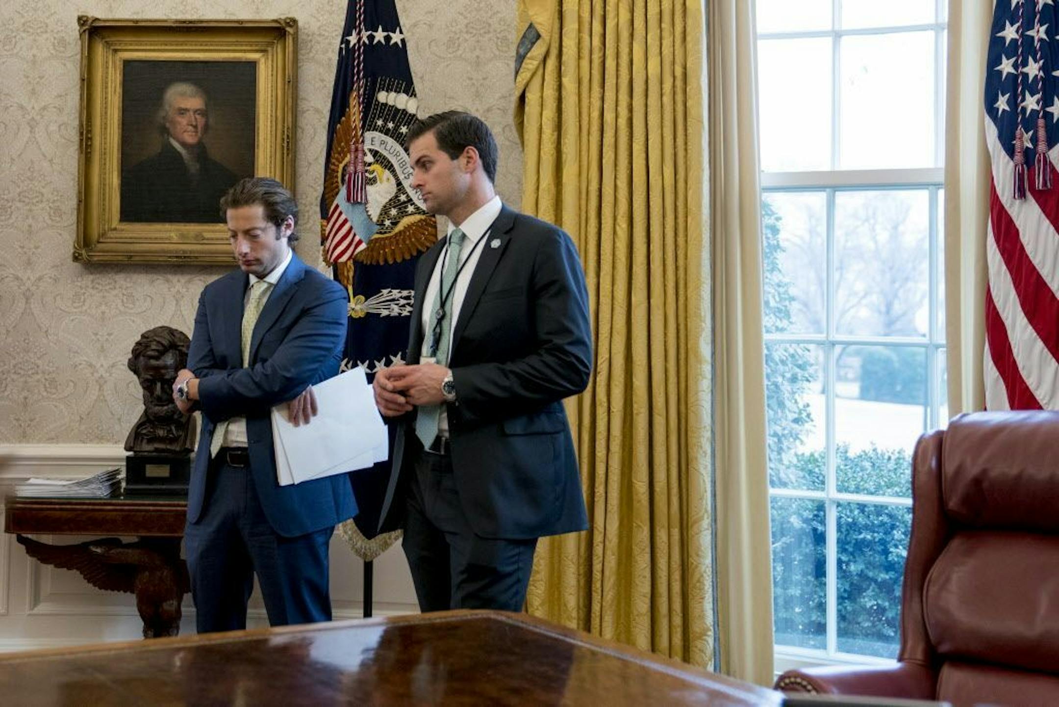 FILE - In this Jan. 31, 2018 file photo, White House aide John McEntee, right, and Treasury Secretary Steve Mnuchin's Chief of Staff Eli Miller, left, stand in the Oval Office as President Donald Trump speaks at a tax reform meeting with American workers at the White House.