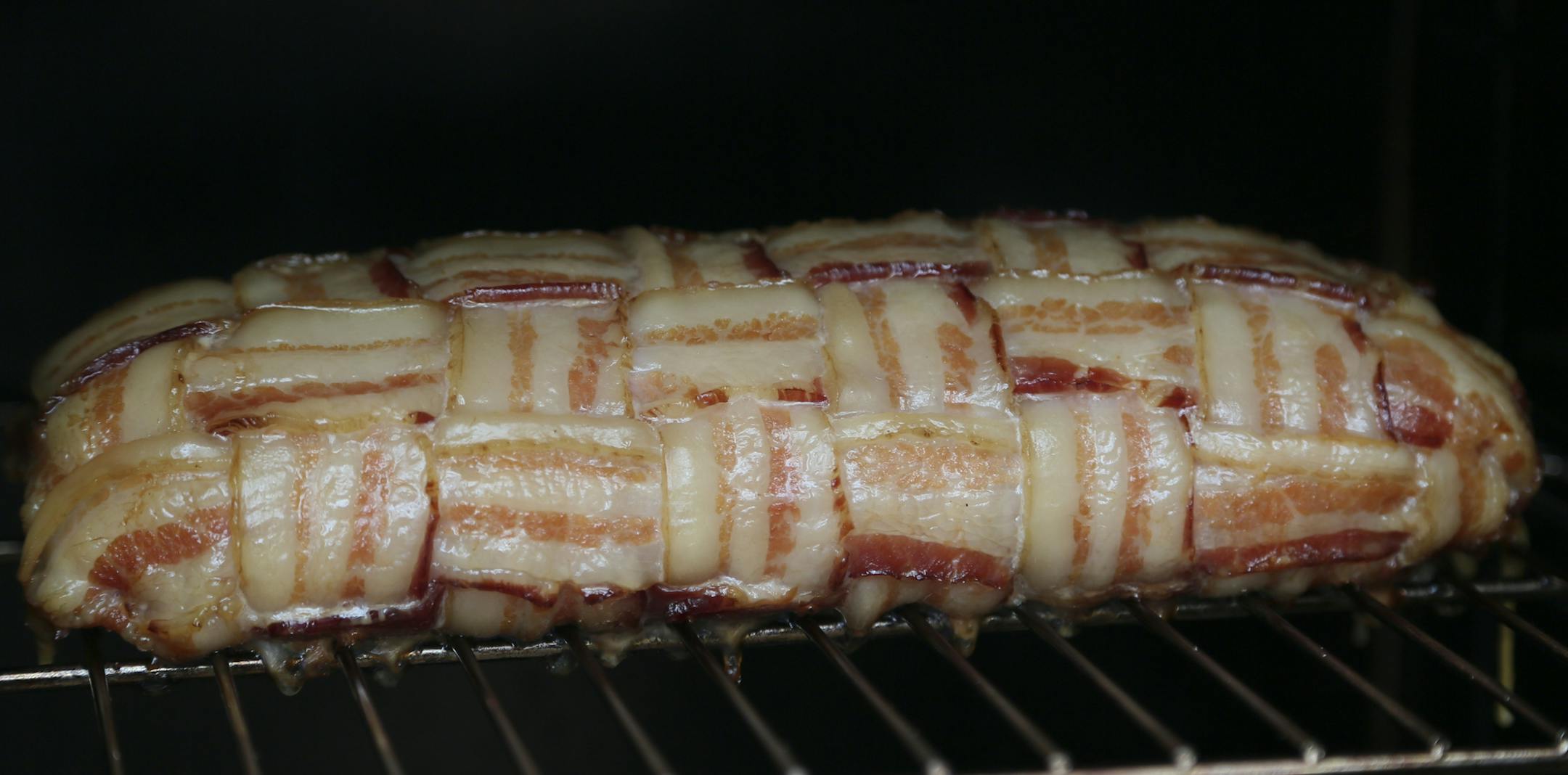 A meat concoction consisting of various types of meat woven with bacon outside slowly smoked during Smokapalooza 2013, on the deck of the Pupel family residence Saturday, May 26, 2013 in Plymouth, MN.](DAVID JOLES/STARTRIBUNE) djoles@startribune How do you learn the intricacies and nuances of user a smoker? By having lots and lots of experiments going on at one time. How do you do that? By gathering 10 families, smokers and grills at the ready, for Smokapalooza. Everyone learns, by successes and