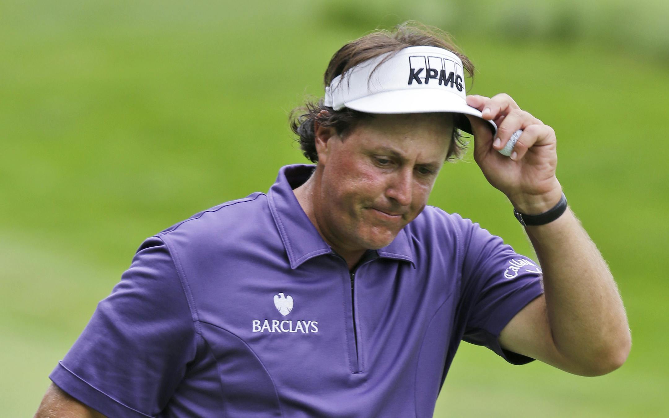 Phil Mickelson walks off the ninth hole after finishing the second round of of the Greenbrier Classic PGA golf tournament in White Sulphur Springs, W.Va., Friday, July 5, 2013. Mickelson ended the round at 2 over par for the tourney. (AP Photo/Steve Helber)