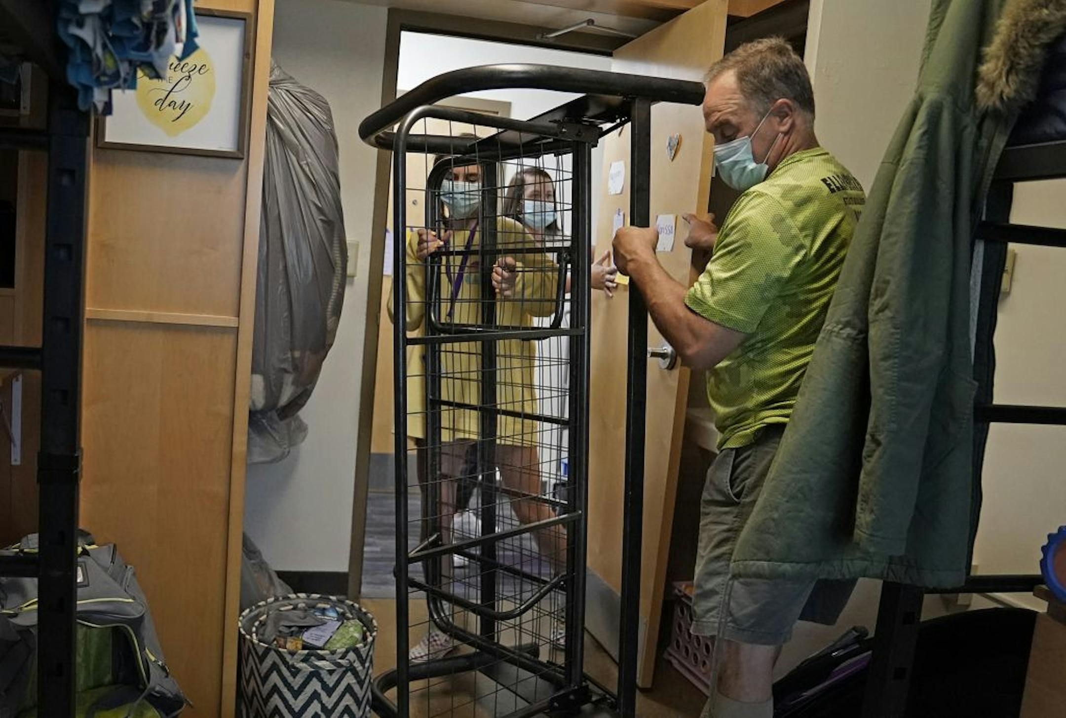 Students began moving into dormitories at Minnesota State University-Mankato Thursday where freshman Marissa Ellenbecker of Edgar, WI, left to right, friend Makenna Guden, and dad Ryan Ellenbecker moved Ellenbecker's belongings into her Crawford Residence.