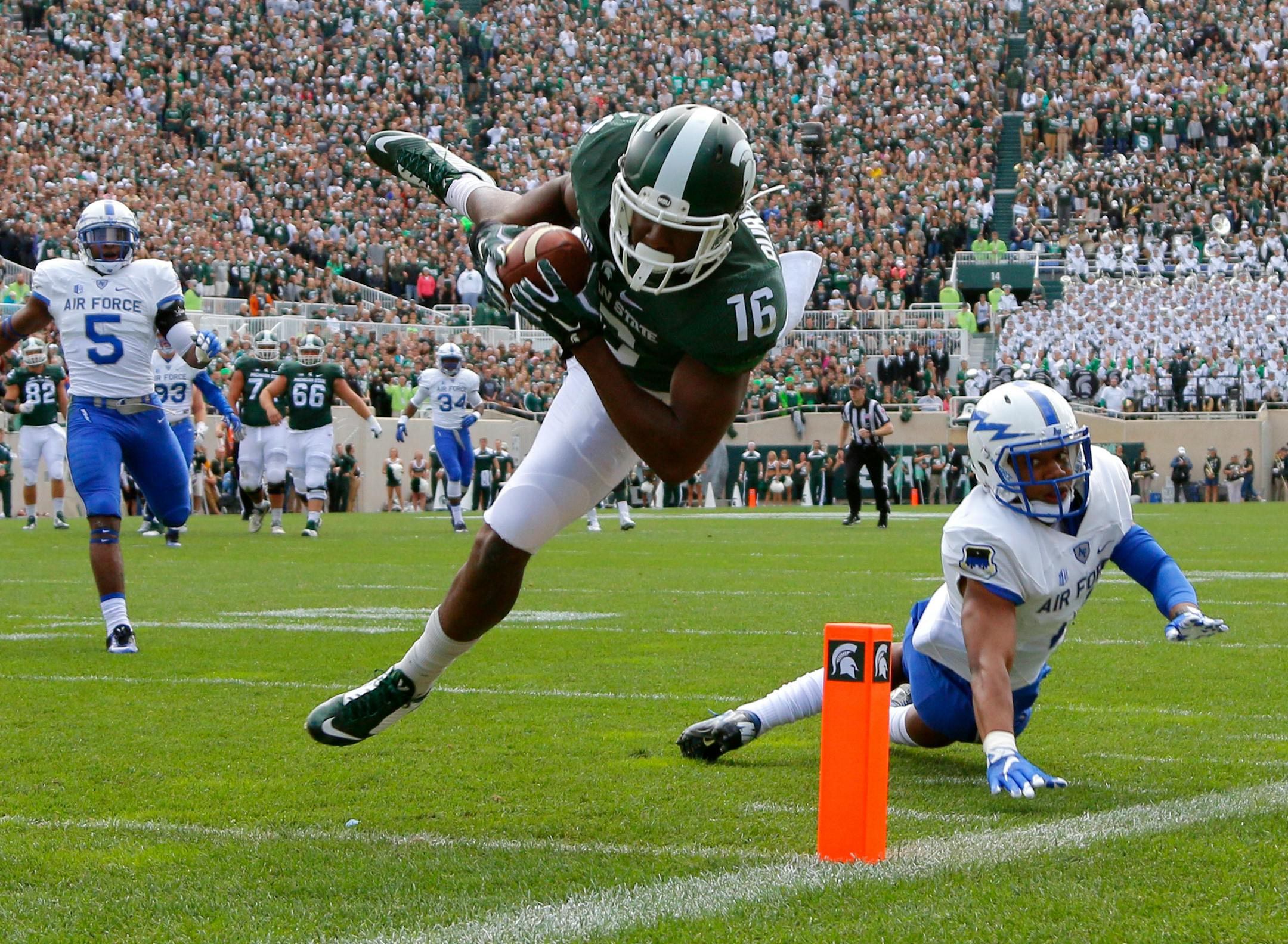 Michigan State's Aaron Burbridge (16) comes down with a 28-yard reception for a touchdown against Air Force's Kalon Baker, right, and Dexter Walker (5) during the second quarter of an NCAA college football game, Saturday, Sept. 19, 2015, in East Lansing, Mich. Michigan State won 35-21. (AP Photo/Al Goldis)