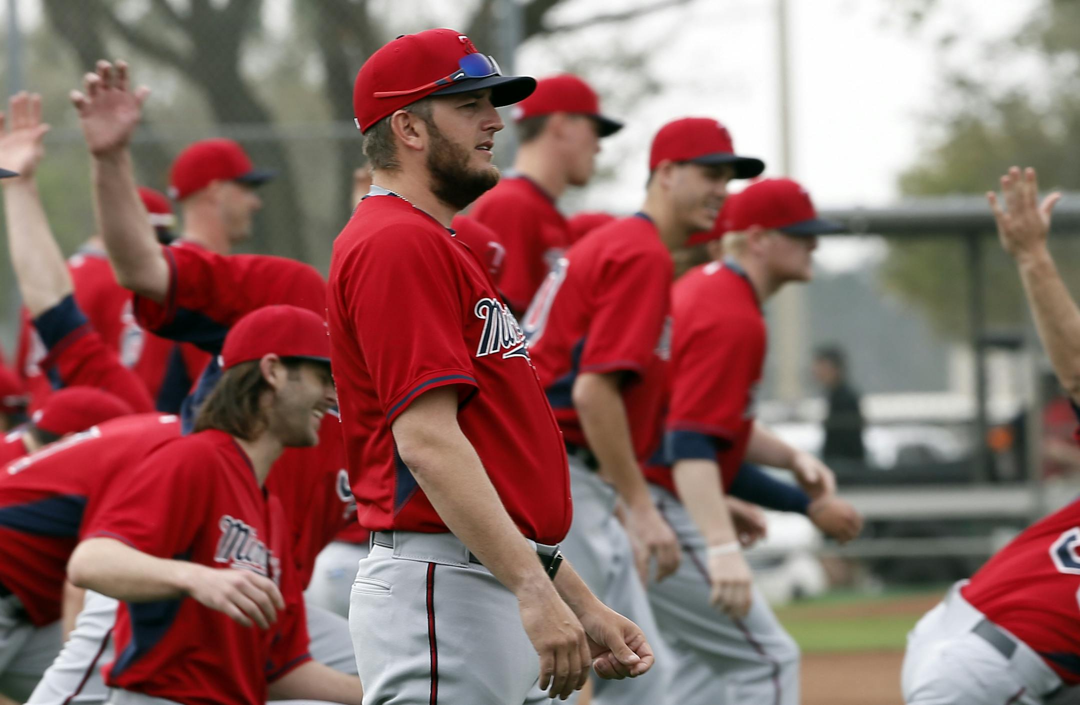 In this Feb. 24, 2015 photo, Twins closer Glen Perkins (front) stretched with teammates at the start of a baseball spring training workout in Fort Myers, Fla.
