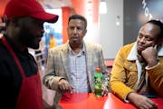 Mathias Shimirana, a refugee from Congo, chats with sponsors Mohamed “Elias” Dawid and Robsan Yusuf, who stopped by as he worked at Nashville Coop
