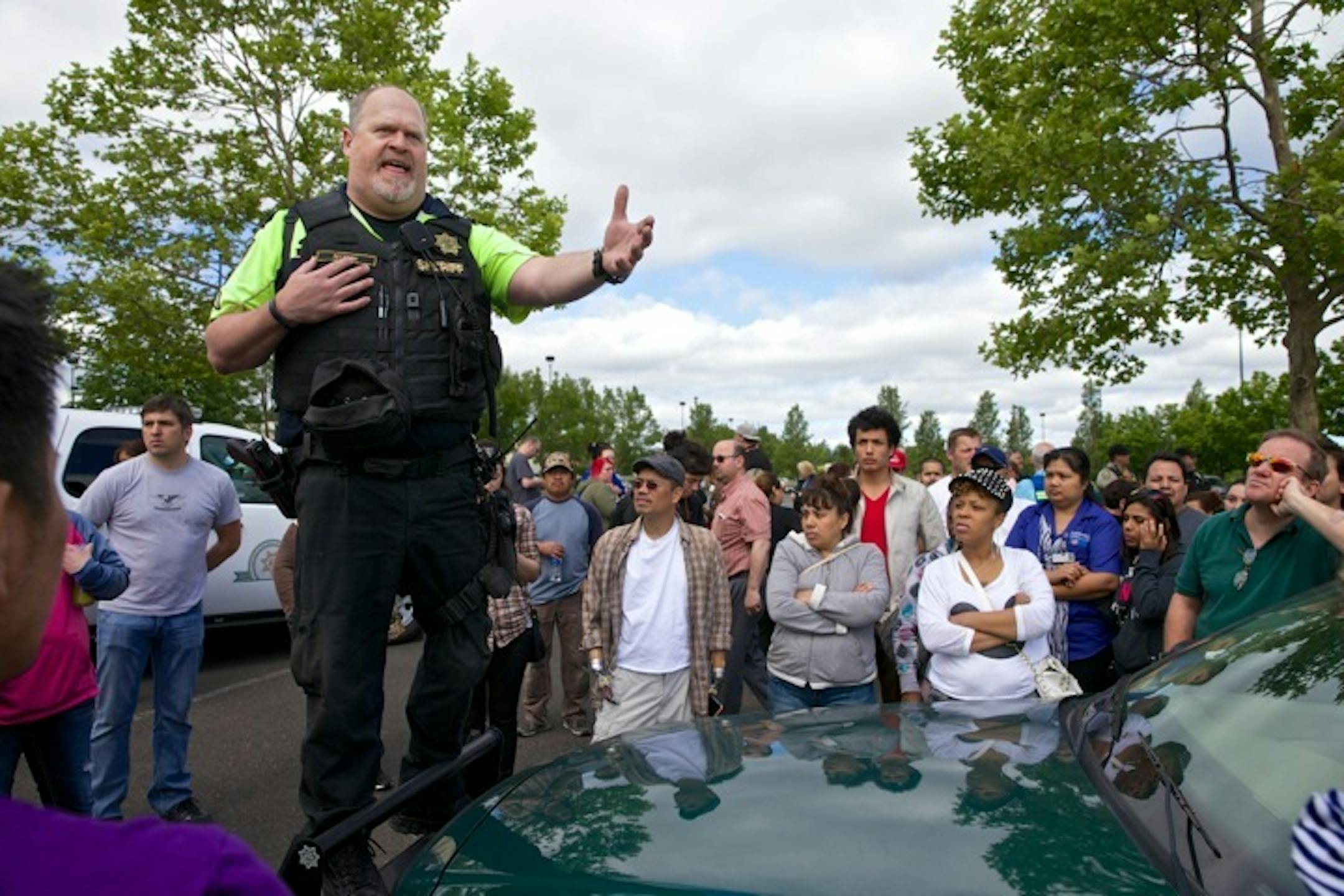 Police instruct family members on where to pickup students after a school shooting at Reynolds High School in Troutdale, Ore., on Tuesday, June 10, 2014. One student and the suspected gunman are dead in a school shooting outside Portland, Ore., according to the police. The Multnomah County sheriff's office said there were reports of shots fired about 8 a.m. Students said they were told over the intercom there was a lockdown and to quietly go to their classrooms. (AP Photo/The Oregonian, Thomas B