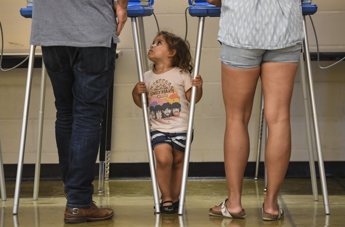 Harper Stone, 2, looked to her father and mother, Mandela and Tommy, as they voted Tuesday night at Edison High School in northeast Minneapolis. "It's important to have a say and to make sure we get the right person in office," said Tommy. Mandela said "we want to be a good influence to our daughter." ] AARON LAVINSKY &#x2022; aaron.lavinsky@startribune.com Primary elections were held Tuesday, August 14, 2018 in Minneapolis, Minn. We photograph DFL gubernatorial candidate Lori Swanson at her pri