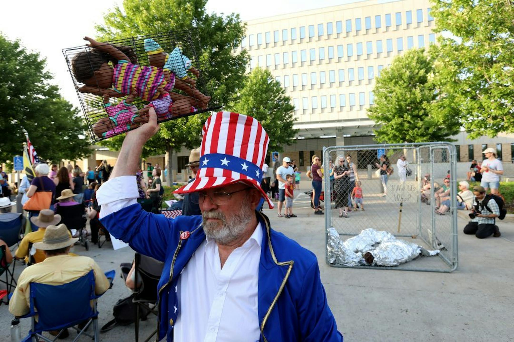 Dressed as Uncle Sam, Clarence Richard of Minnetonka held a small cage with child dolls inside before the start of the Lights for Liberty vigil outside the Whipple Federal Building on Friday at Fort Snelling.
