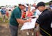 Phil Mickelson signs autographs for fans lined up near the eighteenth hole.