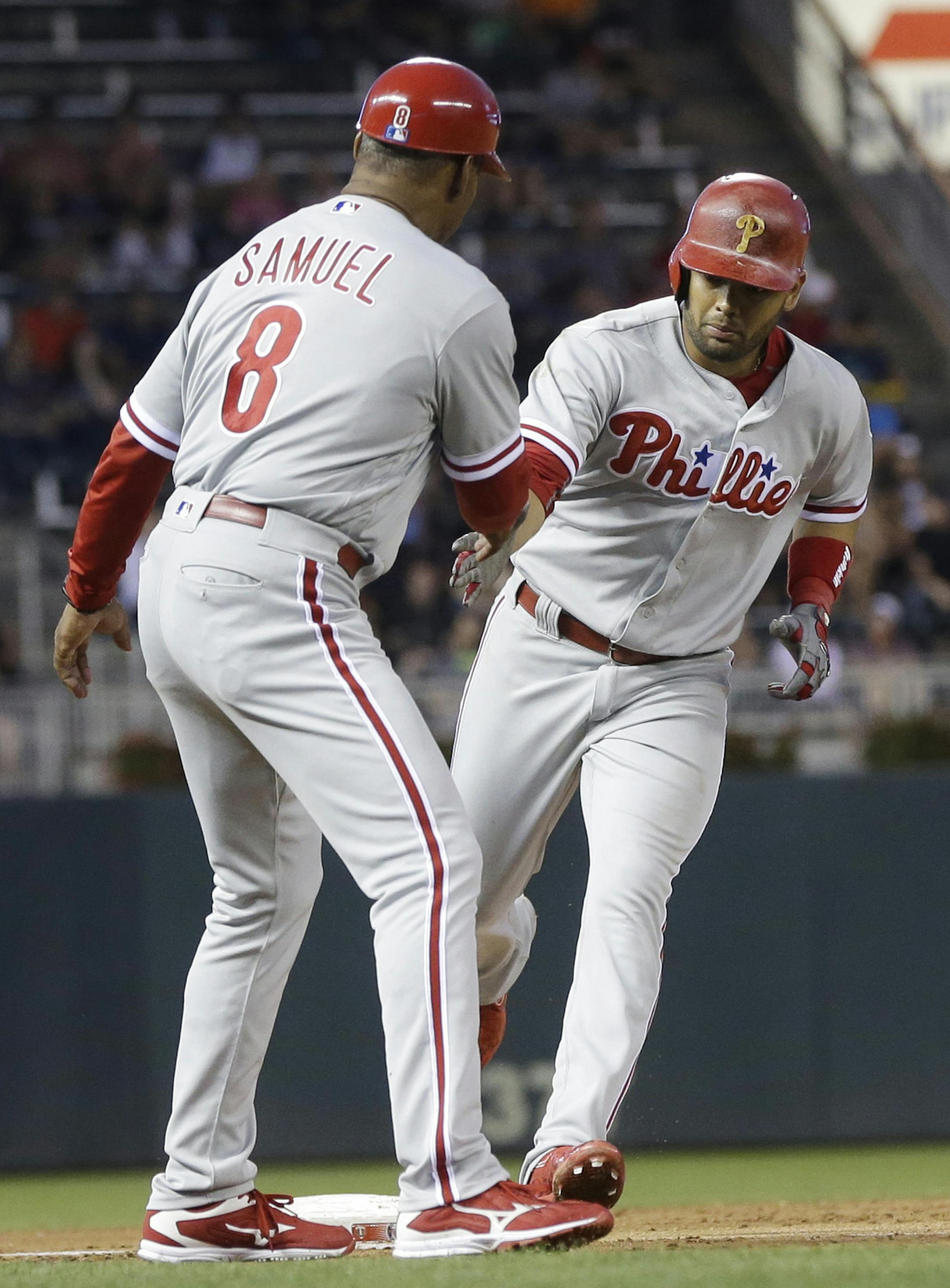 Philadelphia Phillies' Andres Blanco rounds third base and coach Juan Samuel on his solo home run off Minnesota Twins pitcher Kyle Gibson in the third inning of a baseball game Wednesday, June 22, 2016, in Minneapolis. (AP Photo/Jim Mone)