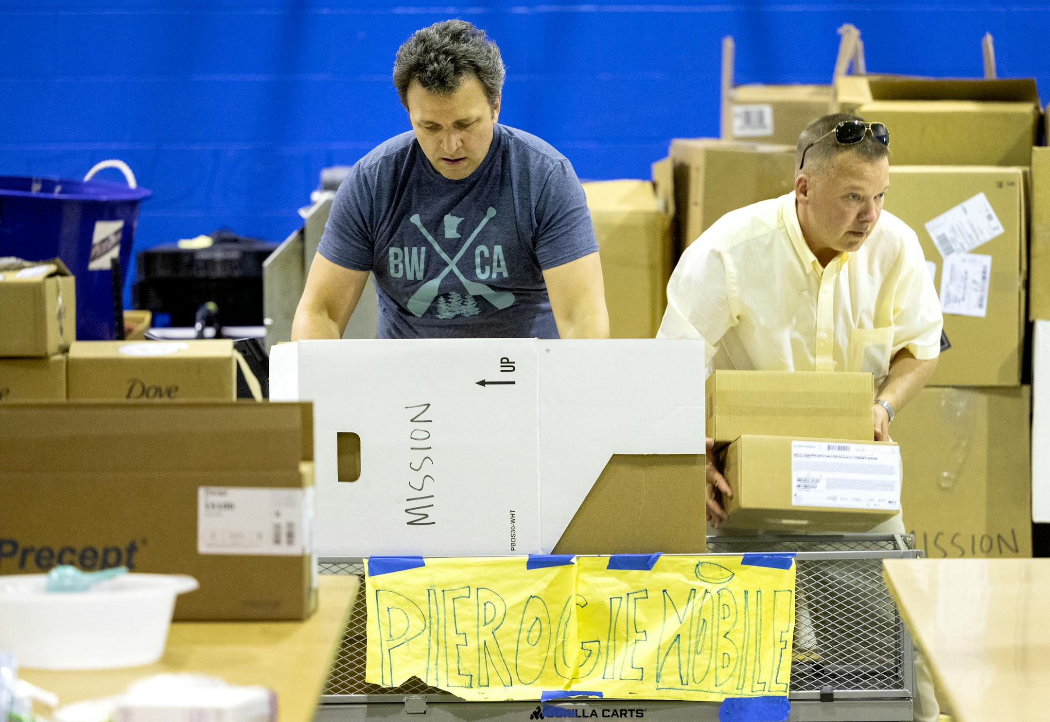 Mykola Sarazhynskyy and Howard Dotson unload a cart of medical supplies at Ukrainian American Community Center.