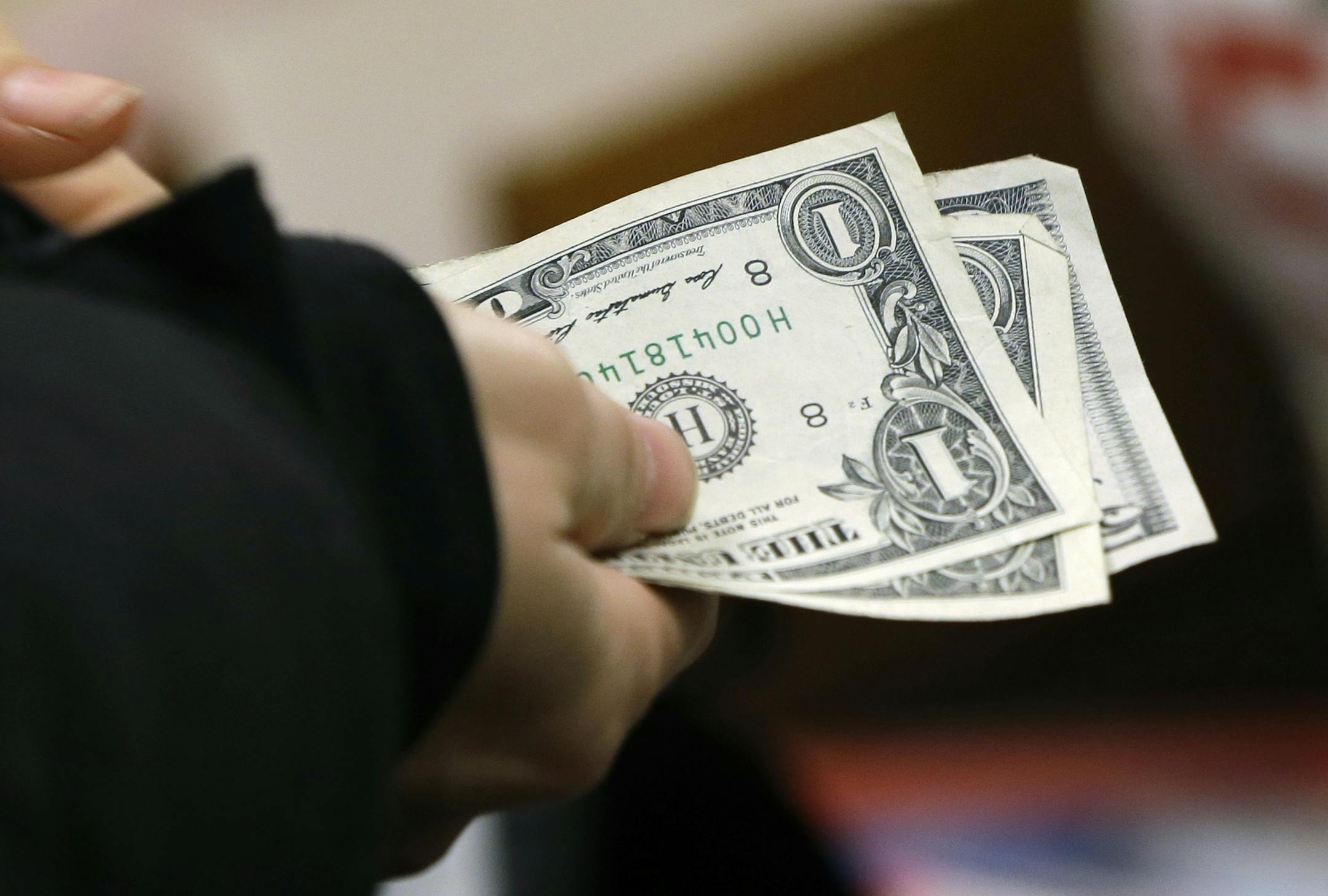 FILE - In this Thursday, Nov. 27, 2014, file photo, a woman pays for merchandise at a Kohl's department store in Sherwood, Ark. A New Yearís resolution to save just one percent more a year can make a big difference when it comes time to retire, according to financial experts. (AP Photo/Danny Johnston, File)