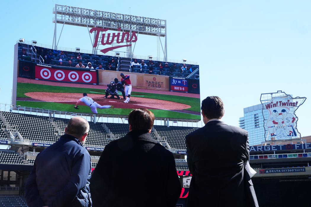 Dave St. Peter, president and CEO of the Minnesota Twins, Margaret Anderson Kelliher, chair of the Minnesota Ballpark Authority, and Matt Hodson, senior manager for business communications, watch as the team unveiled their new scoreboard.