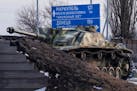 An old German tank stands by a road sign in Rostov-on-Don that points the way to Donetsk and Mariupol in Ukraine. MUST CREDIT: Photo for The Washingto
