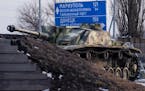 An old German tank stands by a road sign in Rostov-on-Don that points the way to Donetsk and Mariupol in Ukraine. MUST CREDIT: Photo for The Washingto
