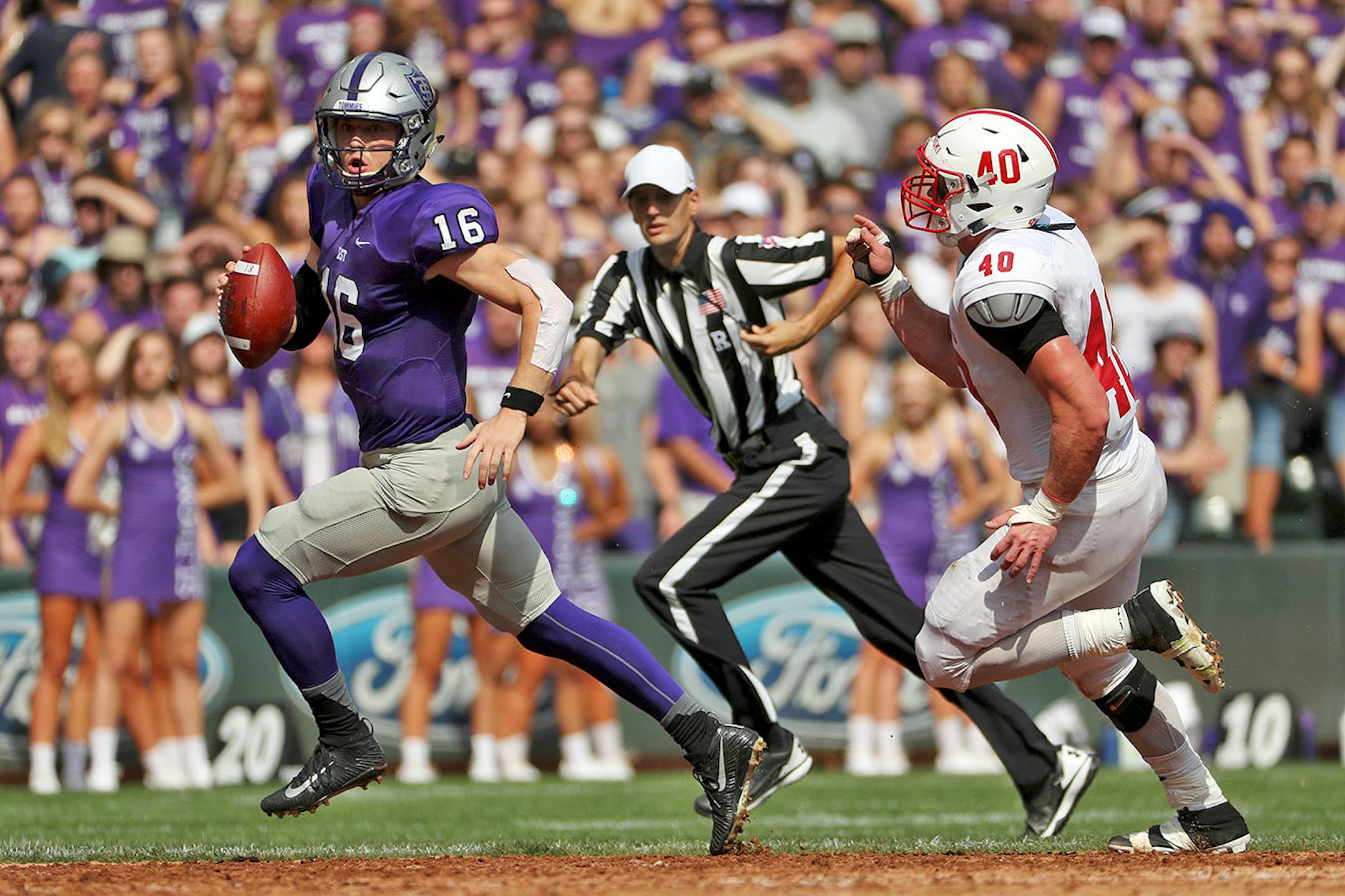 University of St. Thomas quarterback Jacques Perra (16) ran the ball as St. John's University defensive lineman Drew Glenzinski (40) raced after him in the first half.