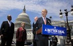 Senate Minority Leader Chuck Schumer of N.Y., accompanied by, from left, Sen. Bob Casey, D-Pa., and Sen. Debbie Stabenow, D-Mich., speaks on Capitol H