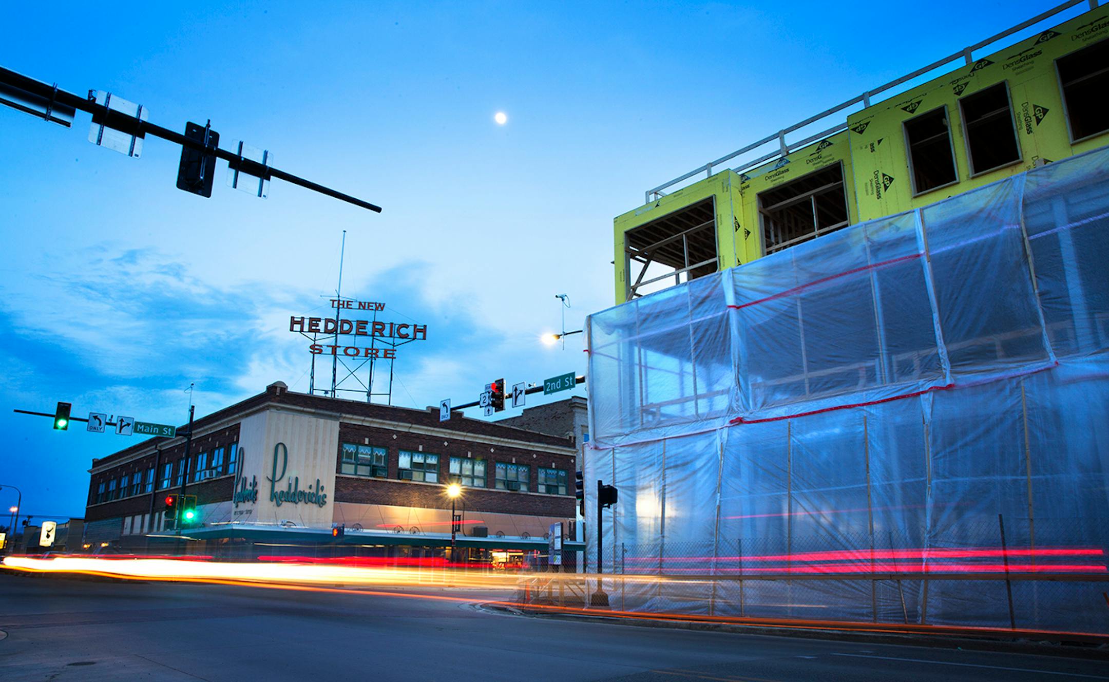 The Renaissance on Main building under construction, at right, contrasts with the 100-year-old Hedderich Building in downtown Williston, North Dakota on Tuesday, March 31, 2015. The Renaissance on Main, set to open in September 2015, will boast apartments, office space and retail.