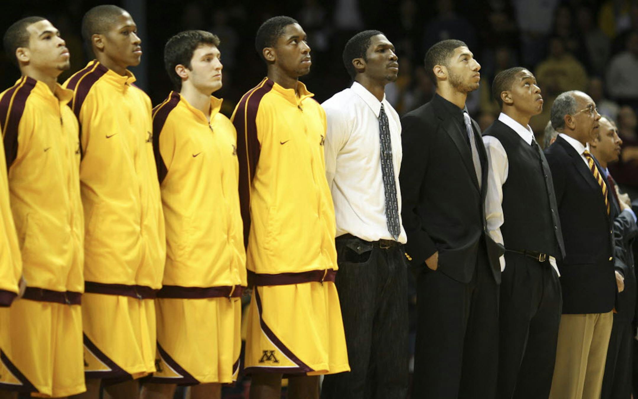 Three Gopher basketball players involved in controversy and not dressed for Nov. 5th's exhibition game against UMD stood next to coach Tubby Smith for the national anthem. They are in street clothes, from left, Trevor Mbakwe, Royce White, and Devron Bostick.