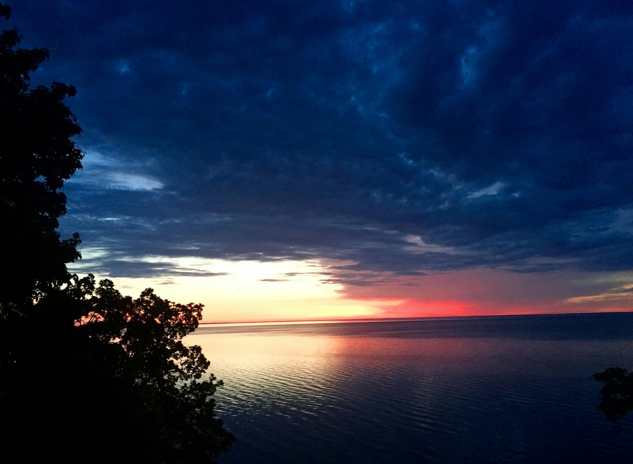 Photographer: RJ Smiley, Edina. Location: Sunrise from the deck of Smiley's lake home south of Garrison. "The minutes before and after were equally as stunning. The picture tells its own story -- the sun is trying to rise and brighten the day is in a battle with dark storm clouds." [focus091816