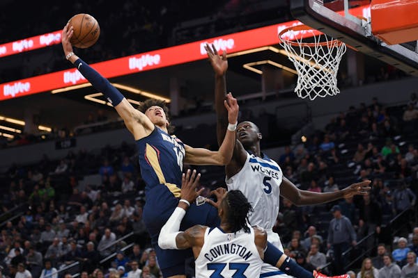 New Orleans Pelicans center Jaxson Hayes goes up to dunk the ball past Minnesota Timberwolves center Gorgui Dieng (5) and over forward Robert Covingto