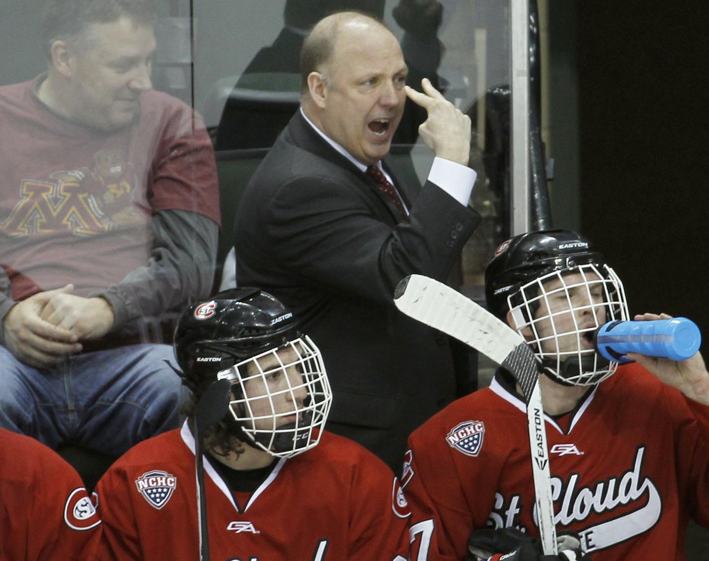 FILE - In this March 30, 2014, file photo, St. Cloud State head coach Bob Motzko, top, gestures to his players during the first period of an NCAA West college regional hockey game against Minnesota, in St. Paul, Minn. The new men&#xed;s hockey coach at Minnesota will be Bob Motzko, who has returned to his roots after 13 seasons running the program at St. Cloud State. Motzko was hired by the university on Tuesday, March 27, 2018, exactly one week after predecessor Don Lucia held a news conference