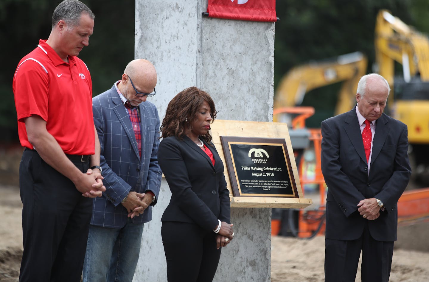 Jason Wenschlag, left, principal of Minnehaha Academy's upper school, Rev. Mark Stromberg, President Donna Harris and chairman of the board David Anderson listened to a prayer during a pillar-raising ceremony Thursday, Aug. 2, at the Minneapolis school.