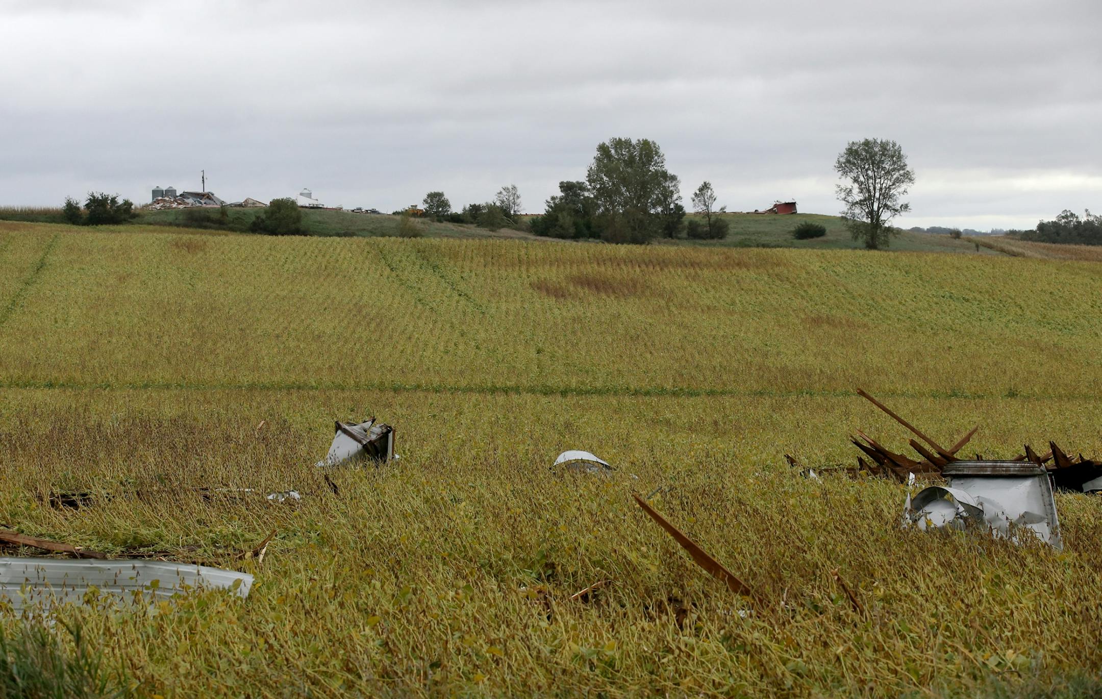 Debris from a destroyed barn and other buildings is strewn in a field near the Red Barn Farm of Northfied, destroyed by storms Thursday evening Friday, Sept. 21, 2018, in Northfield, MN. A turkey farm at upper left was also destroyed, as was another barn at the upper right.