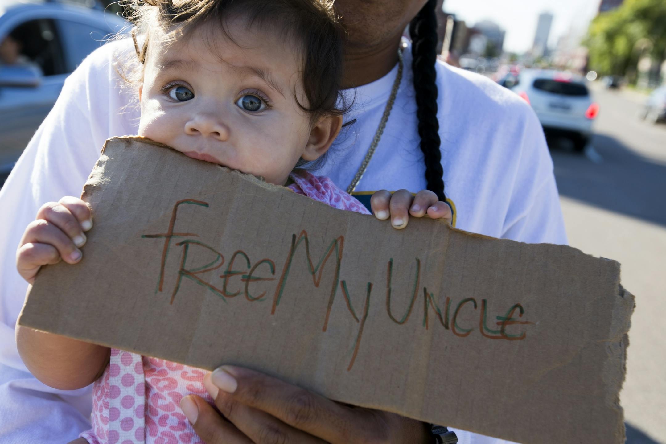 Six-month-old Aubrey Phan holds a sign for her uncle Chamrouen Phan, who was detained by ICE in late August.