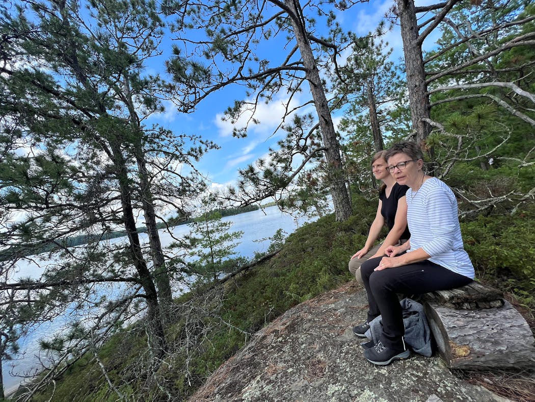 Steffi O’Brien, left, executive director, and Patsy Mogush, president, of the Listening Point Foundation, sit where Sigurd Olson once sat overlooking Burntside Lake.
