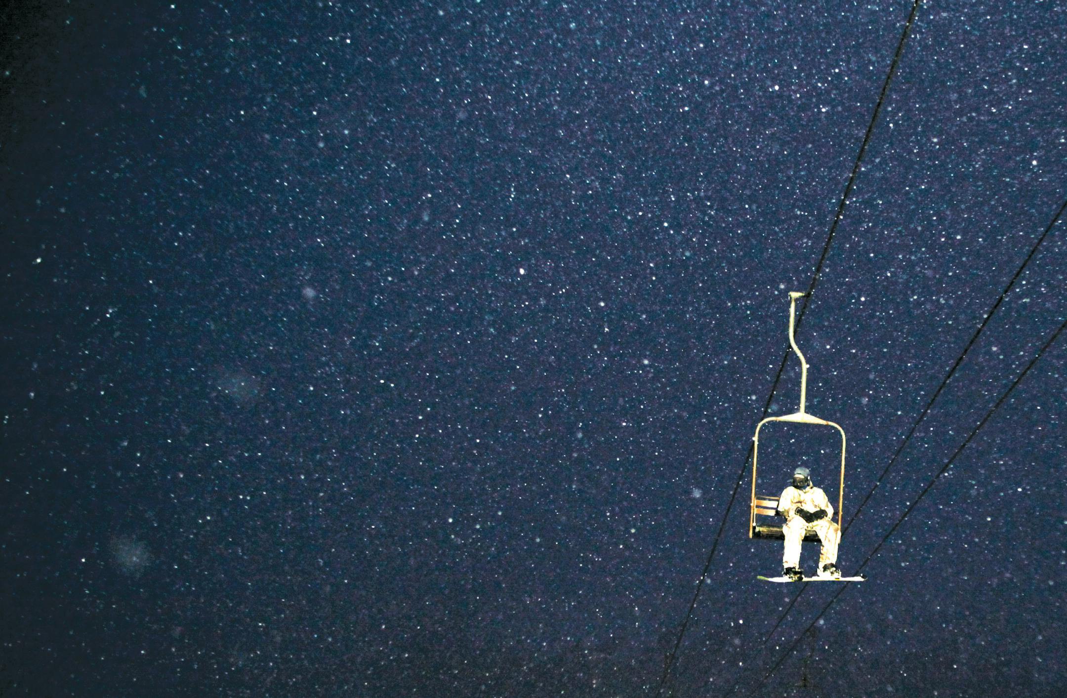 A skier rides a lift up the mountains at the Alyeska Resort in Girdwood, Alaska, Jan. 19, 2013. Ski resorts around Anchorage must light trails in winter so that guests can ski past 2:30 p.m., but some locals say a good ski is one of the few things that make Alaska's winters bearable. (Tara Todras-Whitehill/The New York Times) -- PHOTO MOVED IN ADVANCE AND NOT FOR USE - ONLINE OR IN PRINT - BEFORE FEB. 23, 2014. ORG XMIT: XNYT120