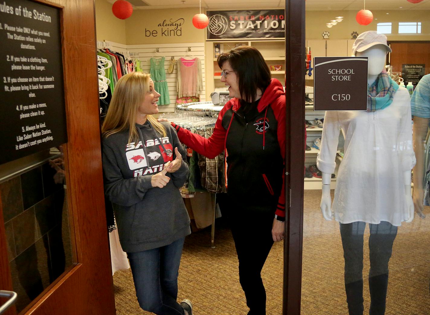 A small boutique store called Saber Nation Station welcomes students at the center of Shakopee's expanded high school, where teens can get personal hygiene items, clothes and other essentials for free. Here, founders Shawn Hallett, a Shakopee school board member, left, and Kristin Koller, right, who both have children in the district and regularly work at the store, paused from tidying up Tuesday, April 10, 2018, at Shakopee High School in Shakopee, MN.] DAVID JOLES &#xef; david.joles@startribun