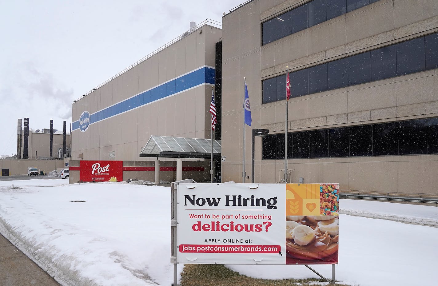 A "now hiring" sign outside of a business.