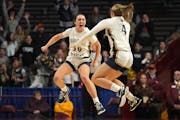 Providence Academy's Maddyn Greenway (30) and Emma Millerbernd go airborne to celebrate their Class 2A girls basketball title at Williams Arena on Sat