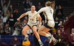 Providence Academy's Maddyn Greenway (30) and Emma Millerbernd go airborne to celebrate their Class 2A girls basketball title at Williams Arena on Sat