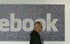 A man walks past a Facebook sign in an office on the Facebook campus in Menlo Park, Calif., Wednesday, June 11, 2014. (AP Photo/Jeff Chiu)