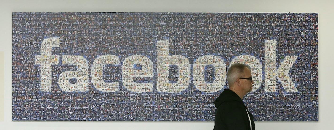 A man walks past a Facebook sign in an office on the Facebook campus in Menlo Park, Calif., Wednesday, June 11, 2014. (AP Photo/Jeff Chiu)