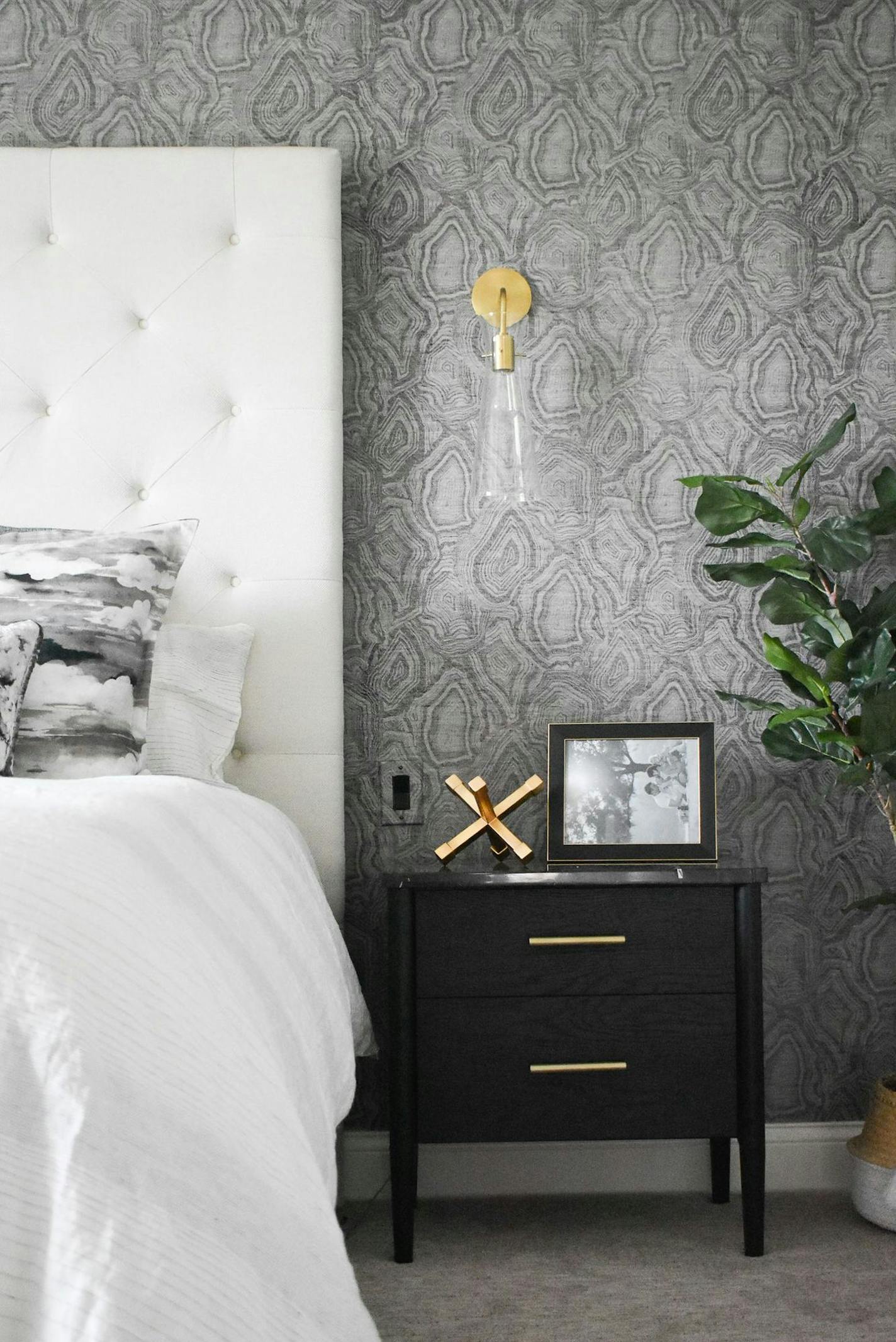 The master bedroom features agate-patterned wallpaper and a new tufted headboard.