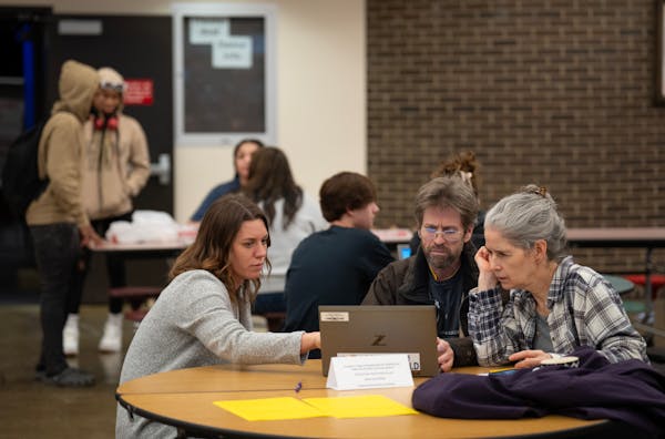 Elizabeth McNamara, left, helps Steve and Nancy Gehrenbeck-Miller fill out the FAFSA form during a financial aid workshop at South High School in Minn