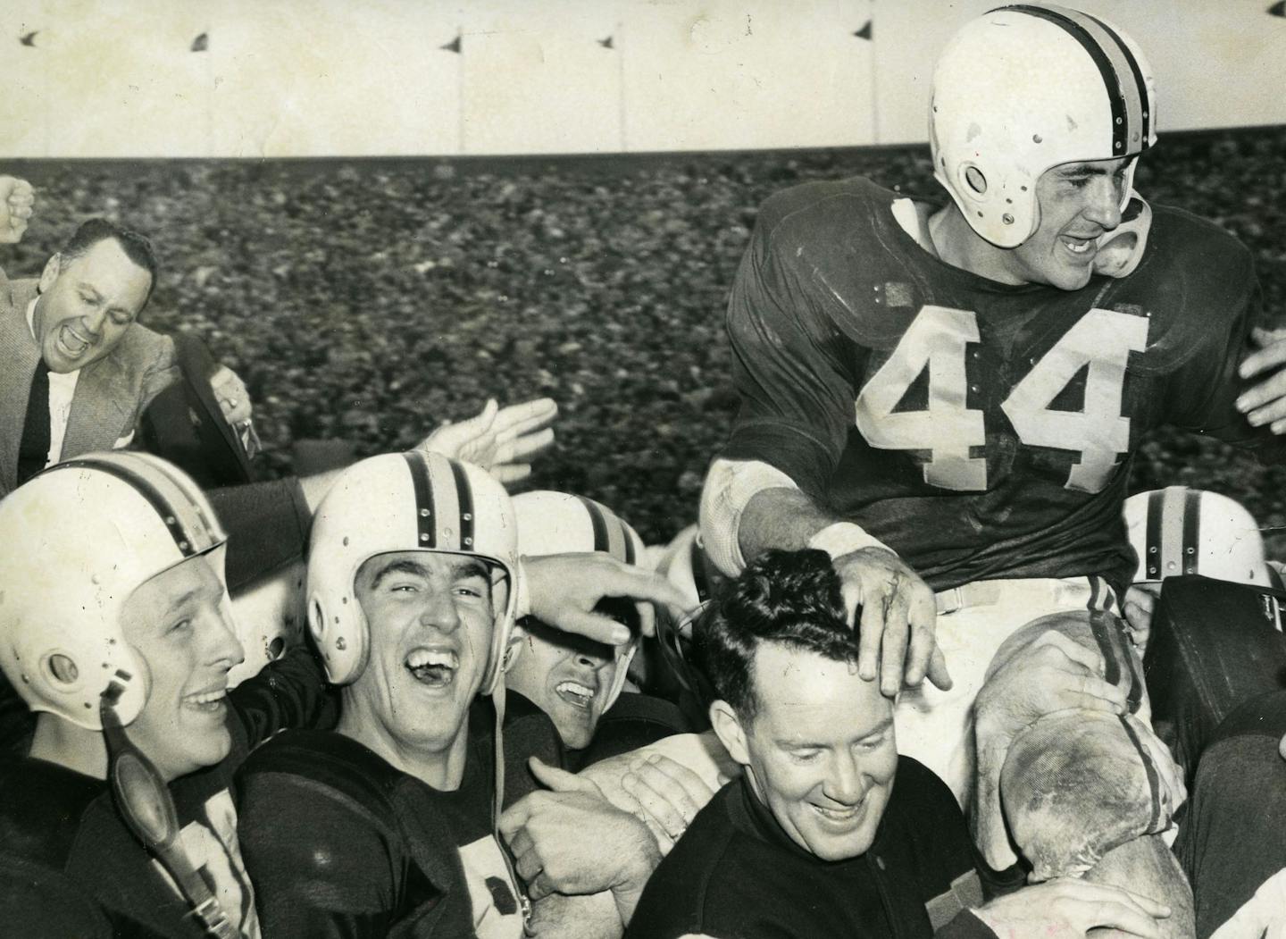 Published Sunday, November 14, 1954 in Minneapolis Tribune. CAPTION: MINNESOTA'S MURRAY WARMATH, TOUCHDOWN ACE BOB McNAMARA--AND GUESS WHO WON! Triumphant Gophers hoist coach, captain in victory ride after downing Iowa Hawkeyes Photo by staff photographer Earl Seubert, November 13, 1954 ORG XMIT: MIN2013092719333420