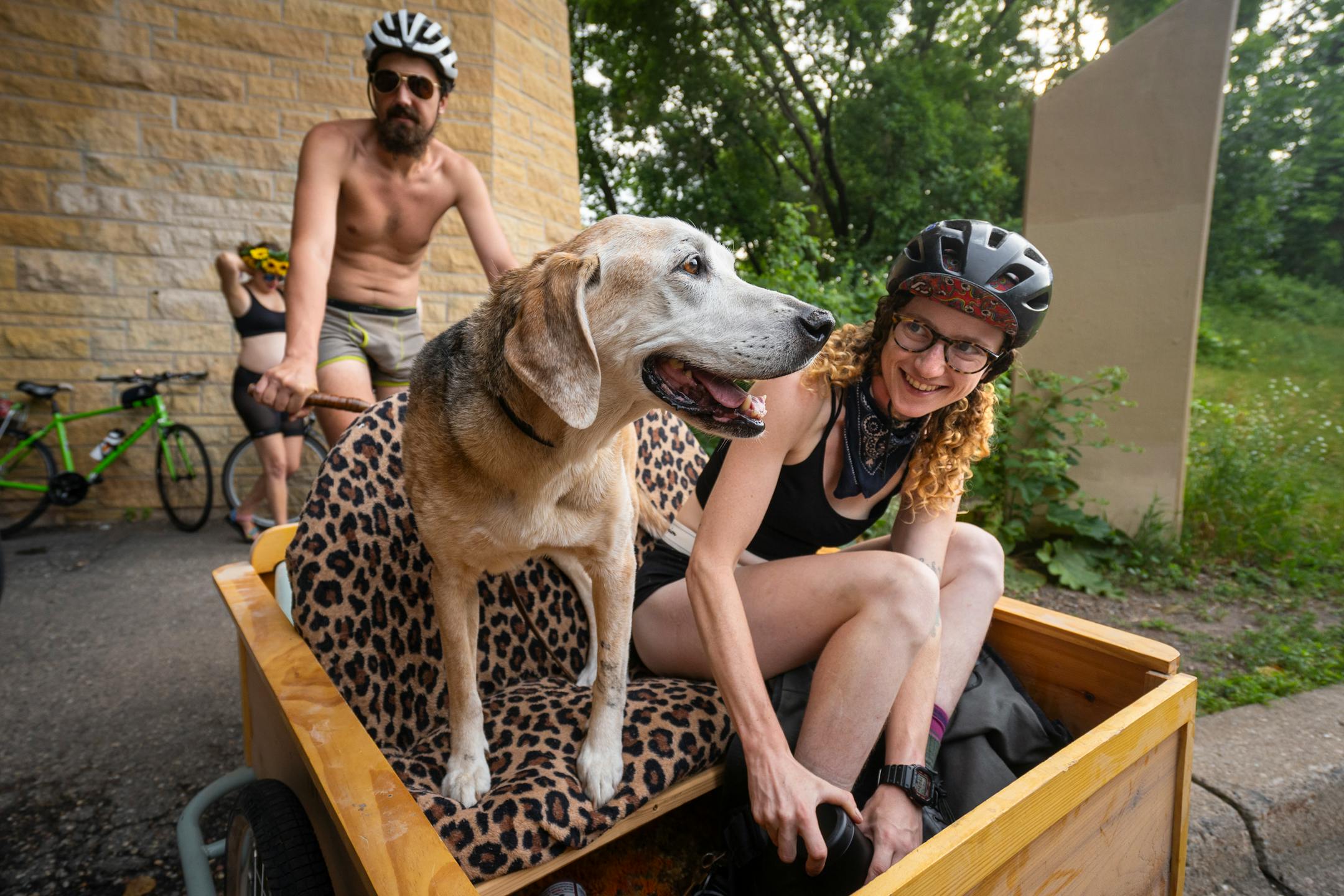 "Ellie" sits with her owners in a cart attached to a bicycle at the annual Freedom From Pants Ride.