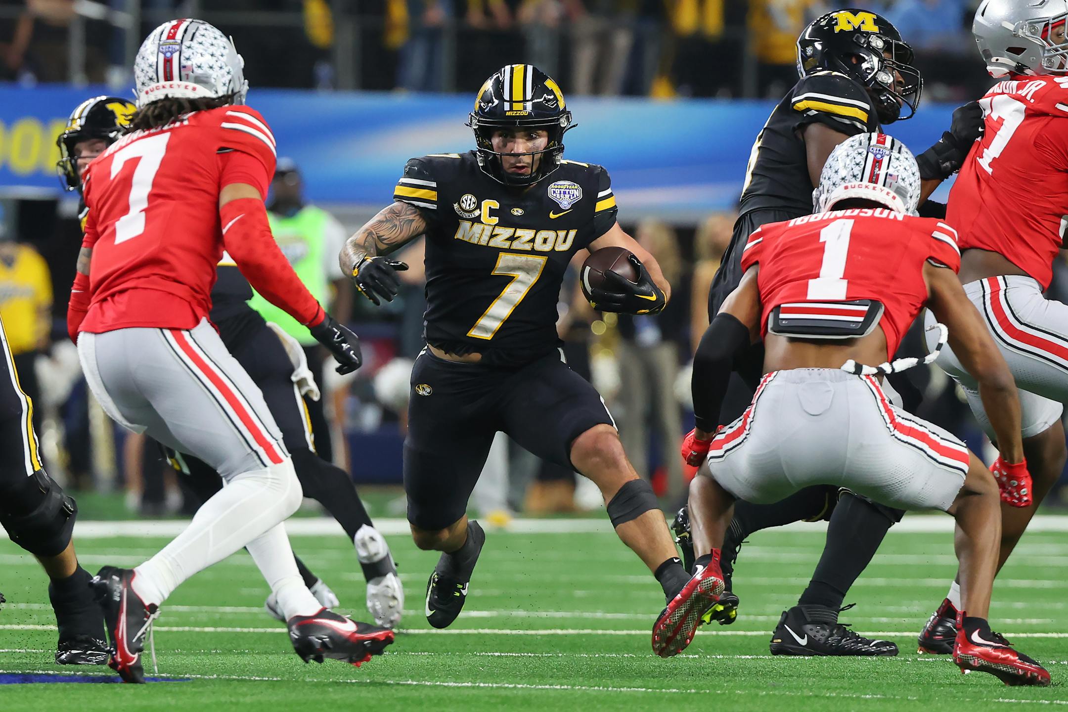 Missouri running back Cody Schrader, middle, ran against Ohio State cornerback Jordan Hancock (7) and cornerback Davison Igbinosun (1) during the second half of the Cotton Bowl